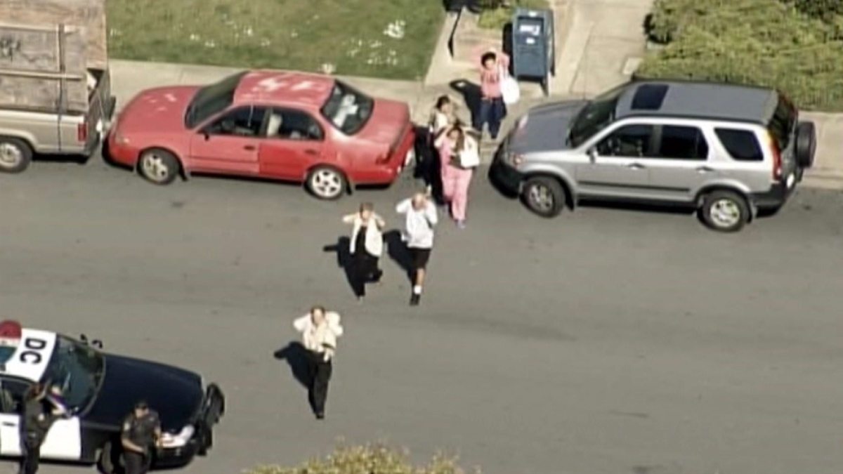 People are seen being led by police away from the medical office building at 1500 Southgate Avenue in Daly City, Wednesday, April 23, 2014.