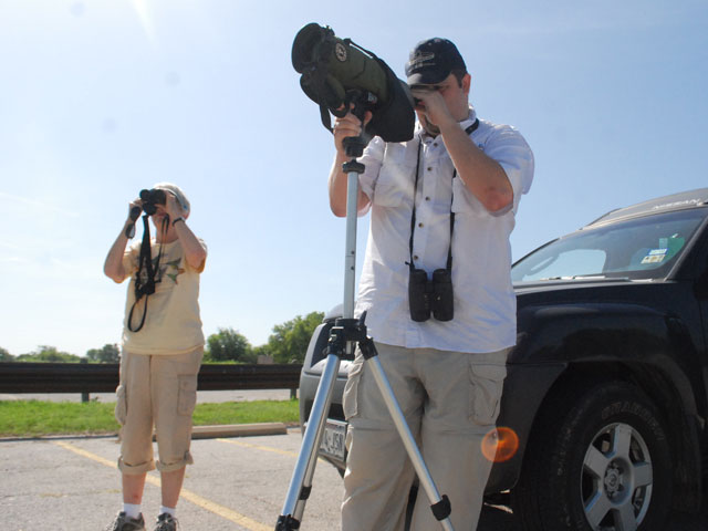 Cook and Thrower use the tools of their trade to spot some birds in the distance at Benbrook Lake.