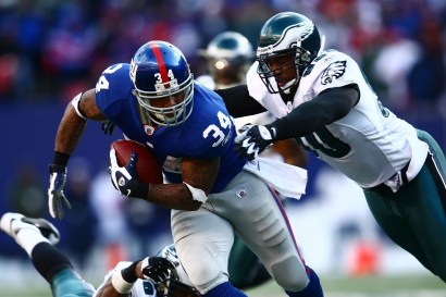Derrick Ward #34 of the New York Giants runs against Darren Howard #90 of the Philadelphia Eagles.