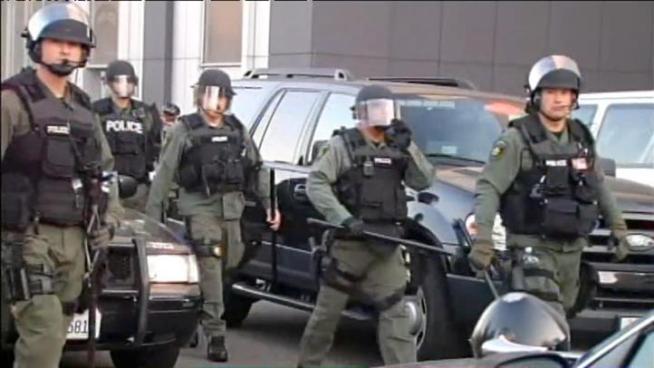 Michael Moore addresses occupy protesters in Oakland outside, while mayor Jean Quan holds a news conference inside.