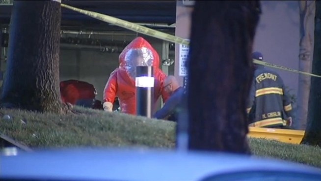 Hazmat crews respond to a Fremont parking garage Wednesday after a woman was found dead in her car. On her windshield, was a sign that said 