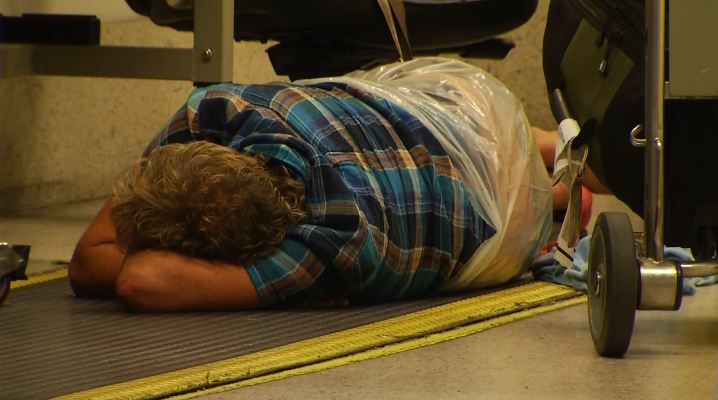 A Norwegian Air Shuttle passenger sleeps on the floor at LAX July 25, 2014. Hundreds of the airline's passengers have been stranded at the airport for days since the Wednesday cancellation of a flight bound for London.