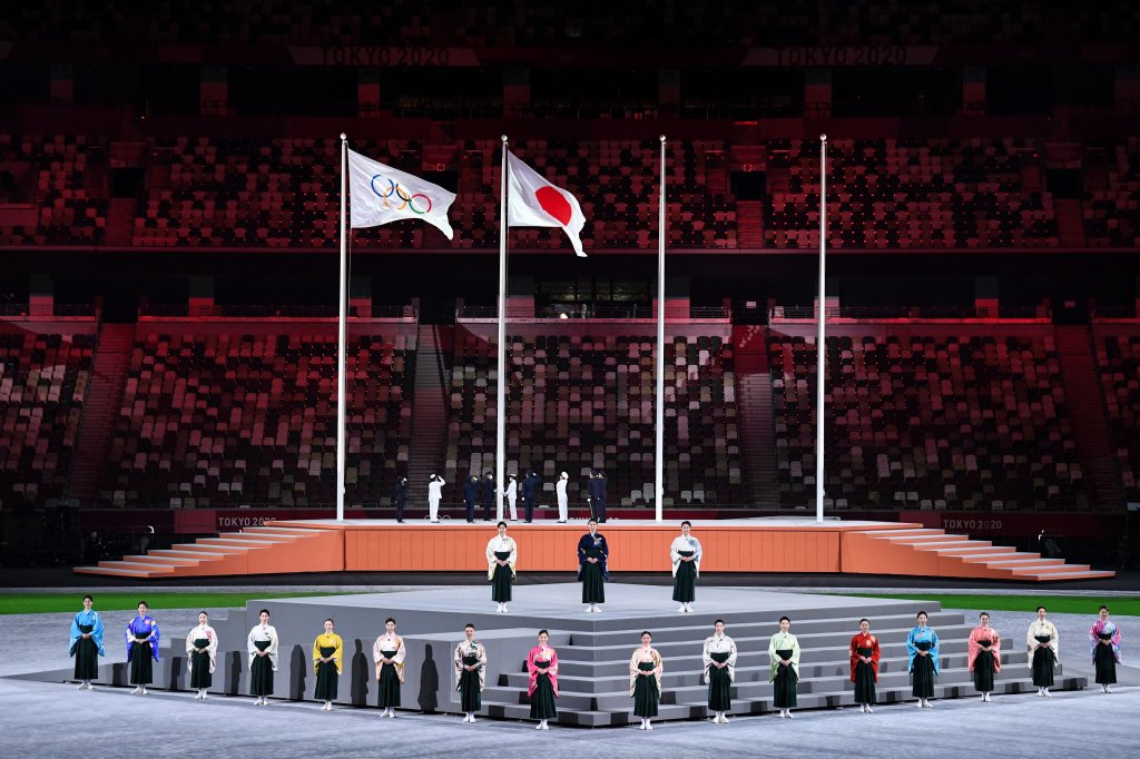 Performers sing the Japanese national anthem as the Olympic flag and Japan's flag are raised during the closing ceremony of the Tokyo 2020 Olympic Games, at the Olympic Stadium, in Tokyo, on Aug. 8, 2021.