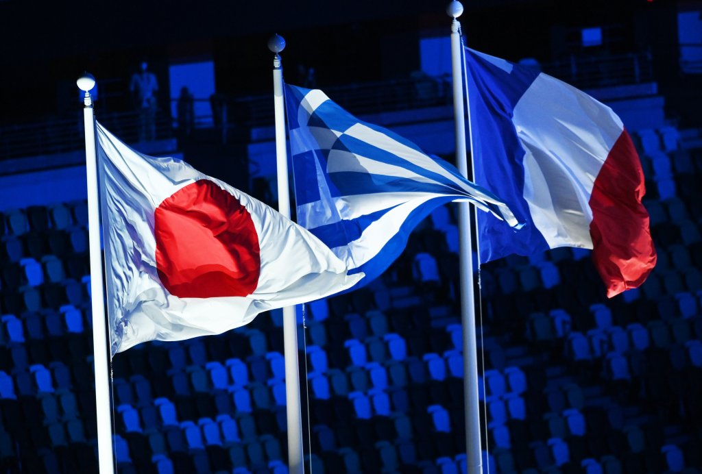 The flags of Japan, Greece and France waves in the Olympic Stadium during the Closing Ceremony of the Tokyo Olympics, Aug. 8, 2021, Tokyo.