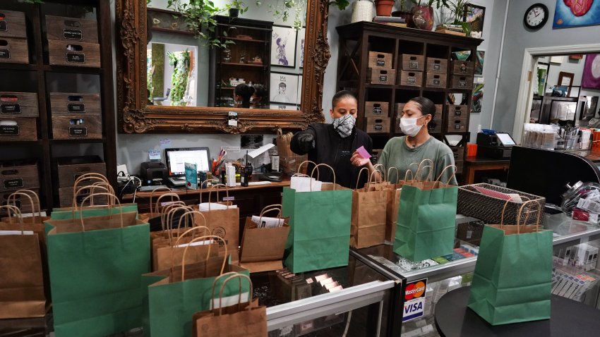 In this Thursday, April 16, 2020, photo, budtenders prepare orders for customers to pick-up at The Higher Path cannabis dispensary in the Sherman Oaks section of Los Angeles.