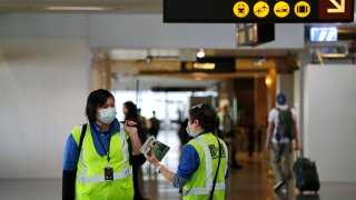 A pair of workers at Seattle-Tacoma International Airport wear masks Tuesday, March 3, 2020, in SeaTac, Wash.