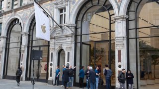 Members of staff stand outside of the Apple Store informing people of their closure, on Regent Street, London, Saturday, March 14, 2020.