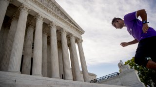 A man exercises on the steps of the Supreme Court where the justices will hold arguments by telephone for the first time ever, Monday, May 4, 2020, in Washington.
