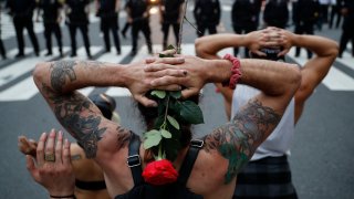 Protesters kneel in front of New York City Police Department officers