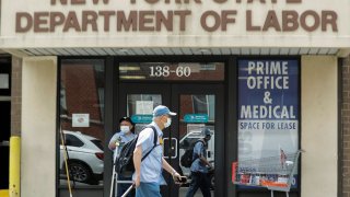 Pedestrians pass an office location for the New York State Department of Labor Thursday, June 11, 2020, in the Queens borough of New York.