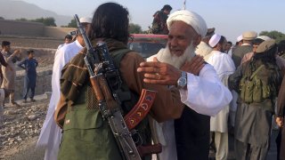 In this June 16, 2018 file photo, Taliban fighters gather with residents to celebrate a three-day cease fire marking the Islamic holiday of Eid al-Fitr, in Nangarhar province, east of Kabul, Afghanistan. Many Afghans view Saturday's expected signing of a U.S.-Taliban peace deal with a heavy dose of well-earned skepticism. They've spent decades living in a country at war -- some their whole lives — and wonder if they can ever reach a state of peace.