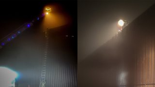 people on tall border fence