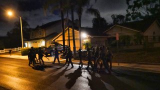 DEA agents move in on a residential house during an arrest of a suspected drug trafficker on Wednesday, March 11, 2020 in Diamond Bar, Calif.