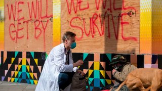 Stuart Malcolm, a doctor with the Haight Ashbury Free Clinic, speaks with homeless people about the coronavirus.