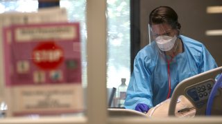 In this May 21, 2020, file photo, a nurse evaluates a coronavirus COVID-19 patient in the intensive care unit (I.C.U.) at Regional Medical Center in San Jose, California.