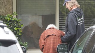 Charlie Campbell a retired RN from Silver City, New Mexico, takes his mom Dorothy Campbell, 88, of Bothell to see her husband Gene Campbell, 89, through his room window on March 5, 2020 at the Life Care Center nursing home in Kirkland, Washington where multiple cases of COVID-19 have been linked and some patients have died.