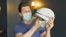 a man holds a medical powered respirator helmet