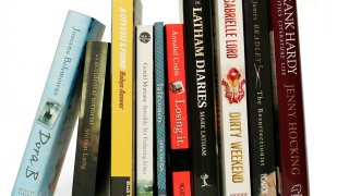 Books stand vertically on a bookshelf.