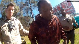 In this still image from body camera video released by the Valdosta police, Antonio Arnelo Smith, center, recovers after being slammed face-first to the ground by a Valdosta police sergeant, in Valdosta, Ga., on Feb. 8, 2020. The video shows Smith handing his driver's license to a police officer and answering questions cooperatively before a second officer, Sgt. Billy Wheeler, approaches him from behind, wraps him in a bear hug and slams him face-first to the ground. Smith is crying in pain when he's told there's a warrant for his arrest. Officers are then told the warrant was for someone else.