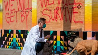 Stuart Malcolm, a doctor with the Haight Ashbury Free Clinic, speaks with homeless people about the coronavirus (COVID-19) in the Haight Ashbury area of San Francisco California on March 17, 2020. – Cities across the nation are worried about the homeless population as the coronavirus pandemic surges with the US death toll reaching 100. (Photo by Josh Edelson / AFP) (Photo by JOSH EDELSON/AFP via Getty Images)
