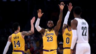 LeBron James #23 of the Los Angeles Lakers celebrates his basket and a Brooklyn Nets foul with Danny Green #14 and Kyle Kuzma #0 during the first half at Staples Center on March 10, 2020 in Los Angeles, California.