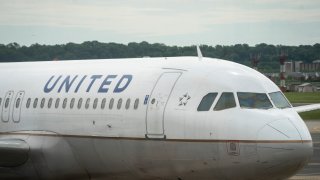A United Airlines plane sits at a gate Ronald Reagan Washington National Airport, May 5, 2020 in Arlington, Virginia.
