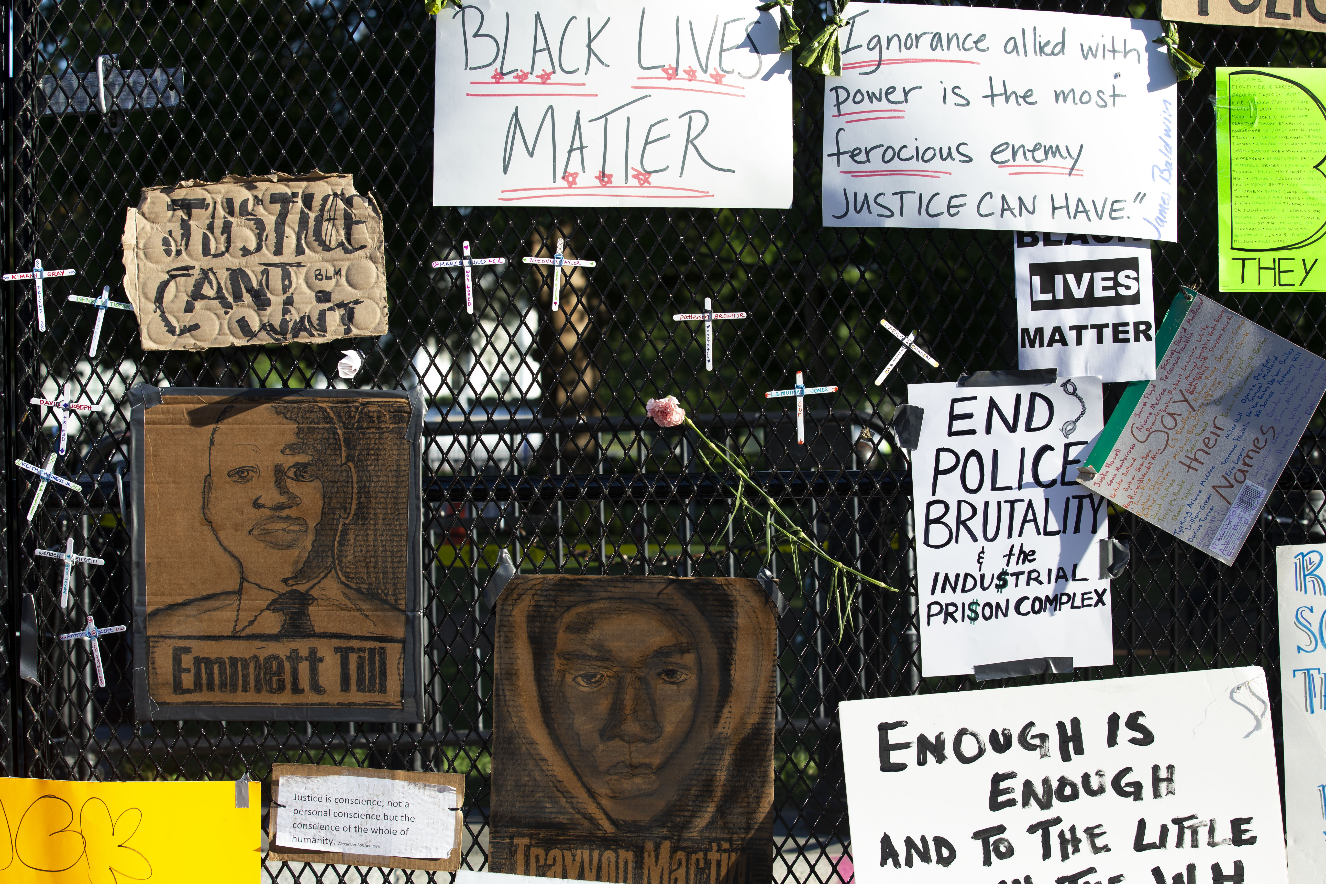 Crosses and drawings of victims of police violence and racism are hung on a fence at Lafayette Square near the White House, during ongoing protests against police brutality and racism, on June 7, 2020. in Washington, D.C.