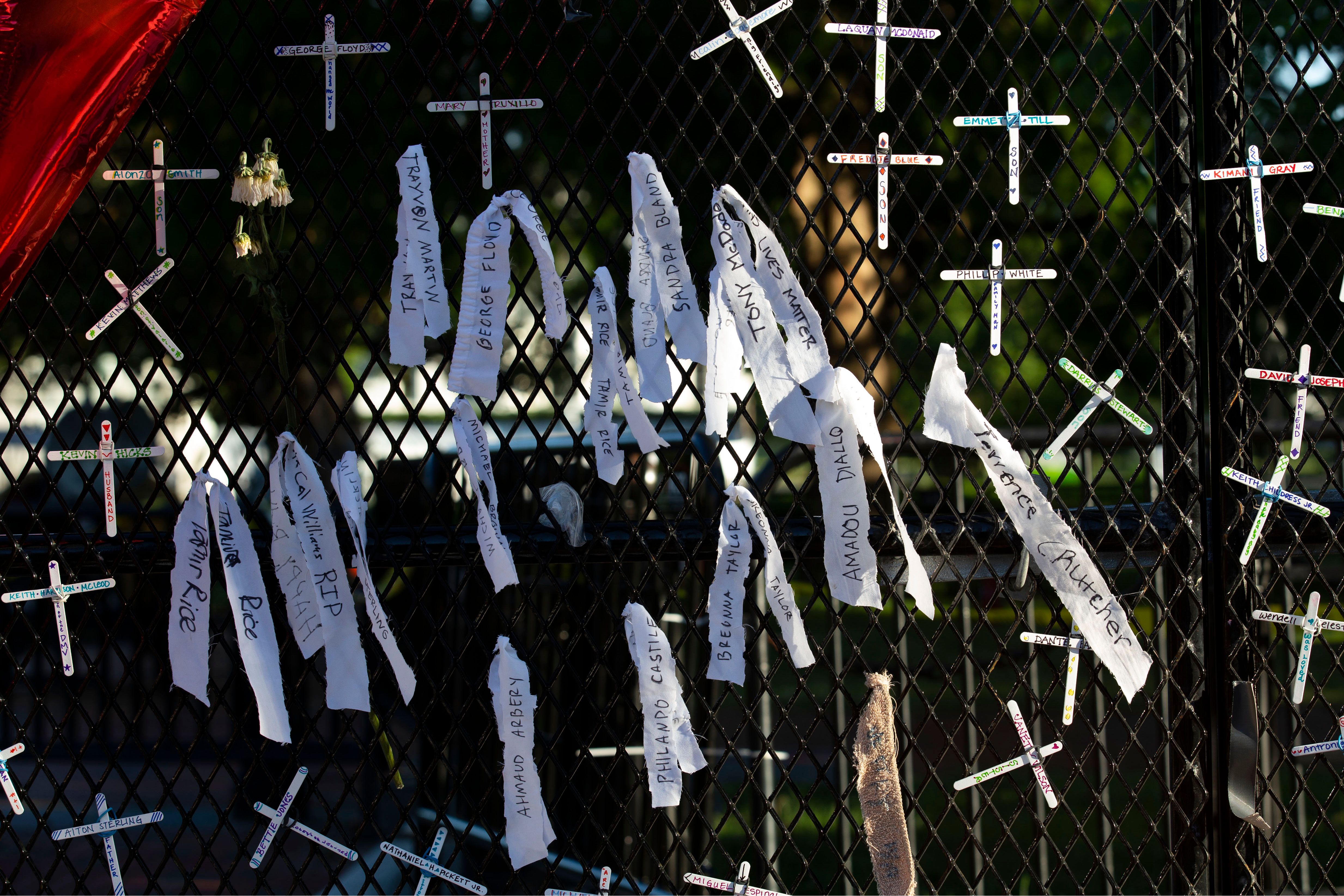 Crosses with the names of people killed by police are hung on a fence at Lafayette Square near the White House, during ongoing protests against police brutality and racism, on June 7, 2020, in Washington, D.C.