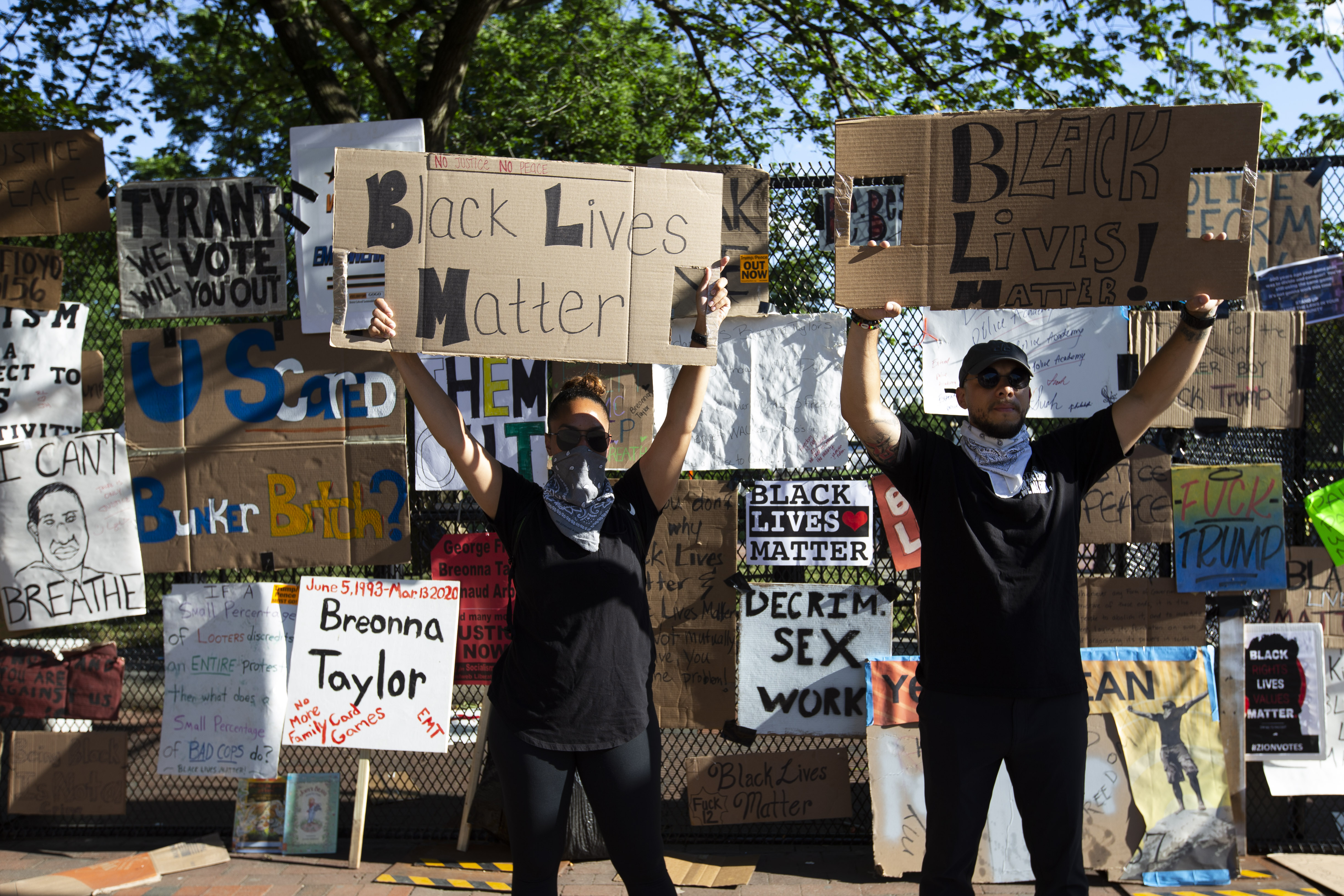 Protesters hold up signs near the White House’s recently erected security fence now turned into a memorial against police brutality and the death of George Floyd, during a peaceful protest on June 7, 2020, in Washington, D.C.