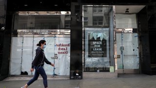 A person walks by closed stores.