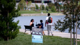 OAKLAND, CA – MAY 16: People visiting Lake Merritt are reminded to take precautions in Oakland, Calif. on Saturday, May 16, 2020. Oakland city officials are strongly discouraging gatherings at the lake and at parks and are reminding people to maintain social distancing during the coronavirus shelter in place orders. (Paul Chinn/The San Francisco Chronicle via Getty Images)