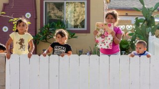 Children watch as hundreds of protesters march through the streets of in Santa Ana on Sunday, May 31, 2020, to protest the death George Floyd, who died in Minneapolis last week after a police officer knelt on his neck for more than eight minutes.