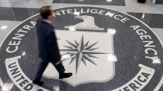 A man crosses the Central Intelligence Agency (CIA) seal in the lobby of CIA Headquarters in Langley, Virginia, on August 14, 2008.