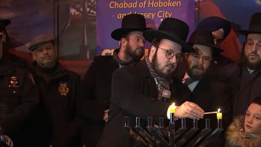 Yoely Greenfeld lights a menorah on the first night of Hanukkah.