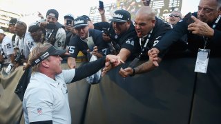 Jon Gruden of the Oakland Raiders celebrates with fans.