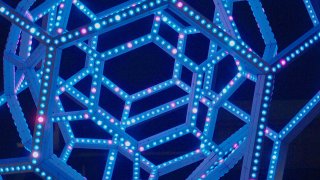 Blue LED sculpture made of concentric geodesic domes, seen at night