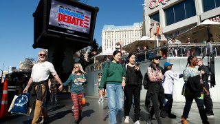 People walk near the Paris Las Vegas hotel casino, site of a Democratic presidential debate, Wednesday, Feb. 19, 2020, in Las Vegas. Nevada's first-in-the West presidential caucus puts the spotlight Saturday on a state that has swung increasingly blue over the last two decades.
