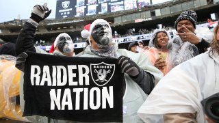 Oakland Raiders fans cheer in the Black Hole.