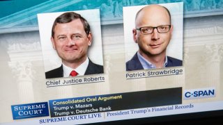 A laptop screen shows still photos of Chief Justice John Roberts and Patrick Strawbridge, an attorney for President Donald Trump, as the Supreme Court convened remotely to hear arguments in two cases dealing with Trump's financial records, May 12, 2020.