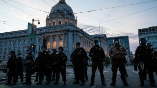 Police officers stand guard in front of City Hall.