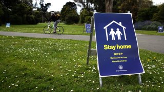 Pedestrians walk by a closed Robin Williams Meadow in Golden Gate Park.