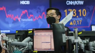 In this April 3, 2020, file photo, a currency trader wearing a face mask works at the foreign exchange dealing room of the KEB Hana Bank headquarters in Seoul, South Korea.