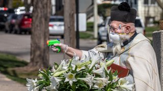 Father Tim Pelc squirts parishioners with his water gun.