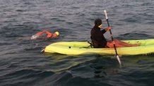 Swimmer behind kayak