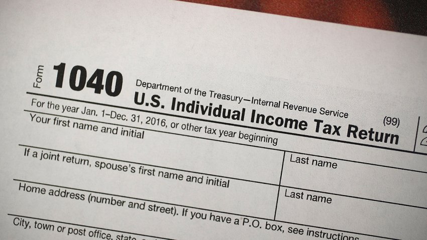 In this Dec. 22, 2017, file photo, a copy of an IRS 1040 tax form is seen at an H&R Block office in Miami, Florida.