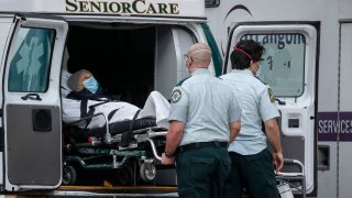 In this April 28, 2020, file photo, a patient is loaded into the back of an ambulance by medical personnel amid the coronavirus pandemic, outside NYU Langone Medical Center in New York.