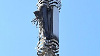 In this Tuesday, April 14, 2020 photo, a view of a cell tower after a fire, in Dagenham, England. Dozens of European cell towers have been destroyed in recent arson attacks that officials and wireless companies say are fueled by groundless conspiracy theories linking new 5G mobile networks and the coronavirus pandemic.