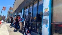 A group of volunteers remove graffiti from a building in Oakland's downtown.