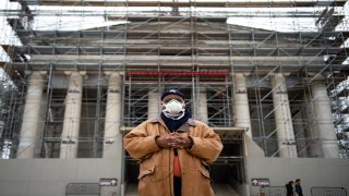 man wears facemask at jefferson memorial