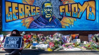 In this May 29, 2020, file photo, flowers, signs and balloons are left near a makeshift memorial to George Floyd near the spot where he died while in custody of the Minneapolis police in Minneapolis, Minnesota.